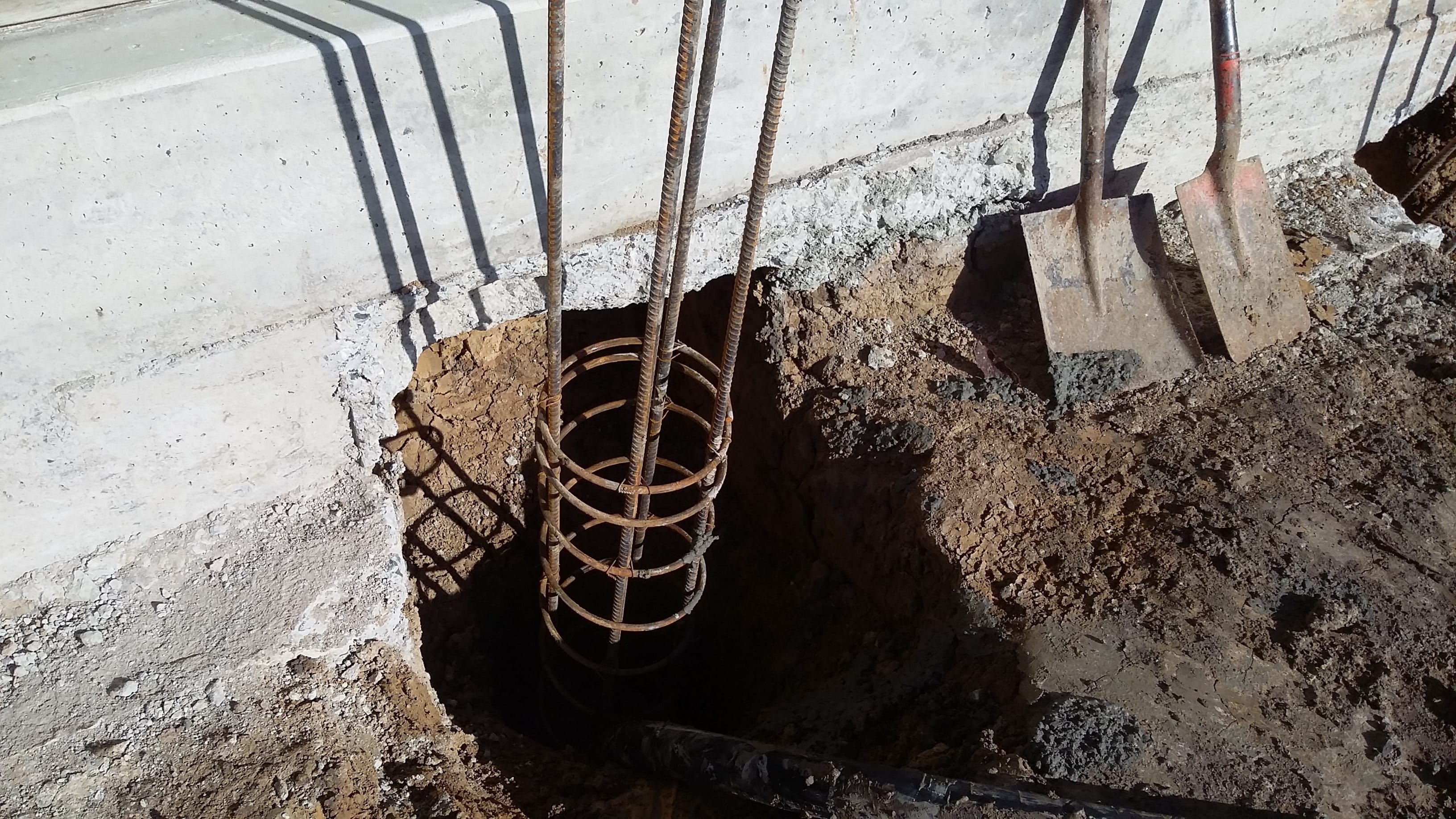 Reinforced concrete pile installation beneath a house during foundation strengthening and house lifting work
