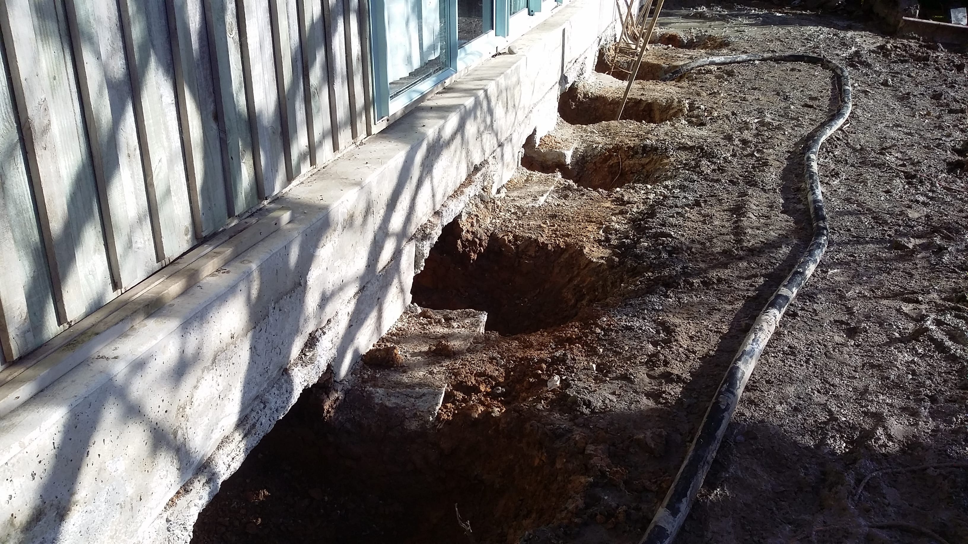 Foundation excavation beside a house for re-piling and structural support installation