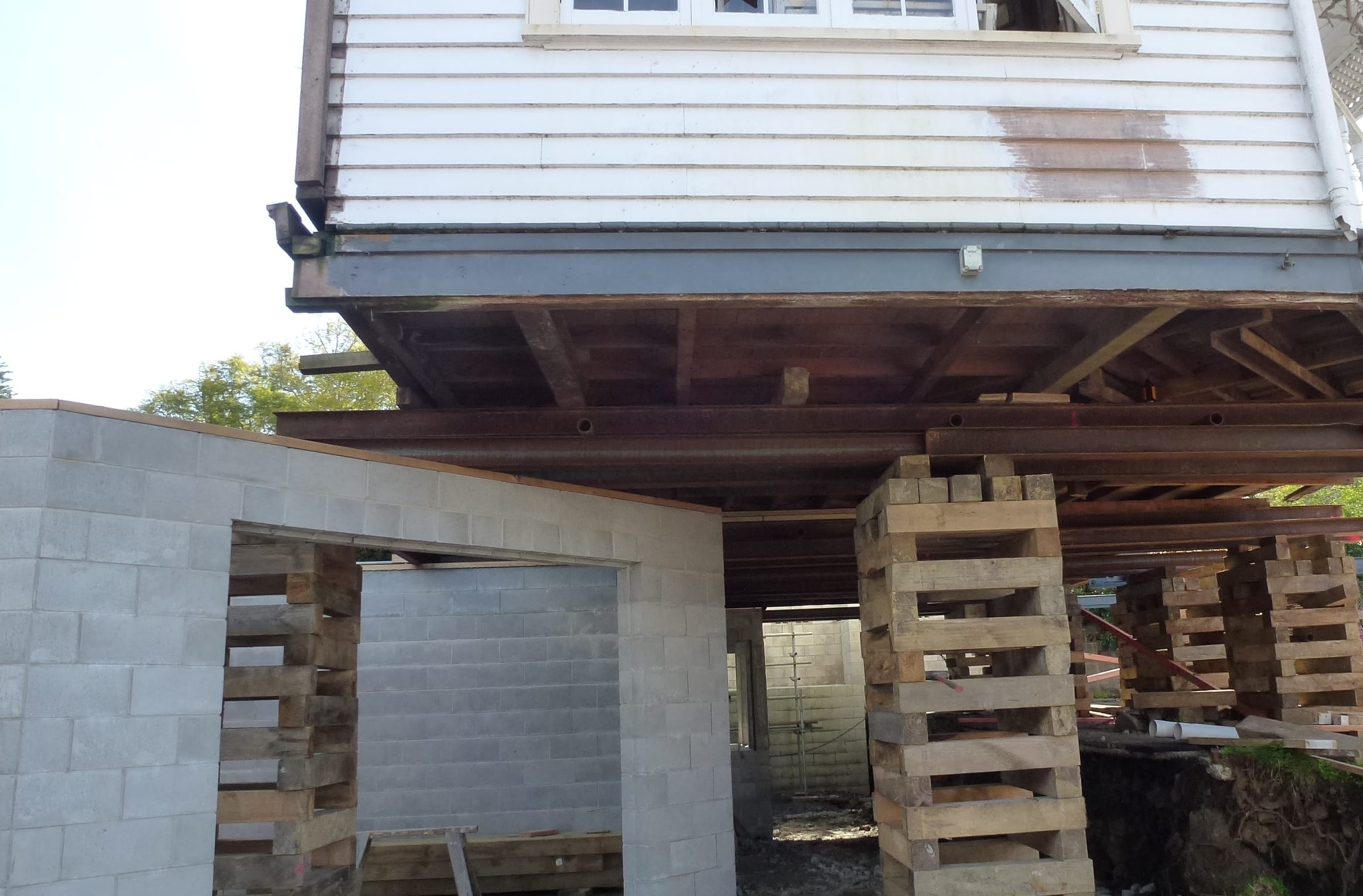 House lifting with timber crib supports while constructing a new concrete block foundation