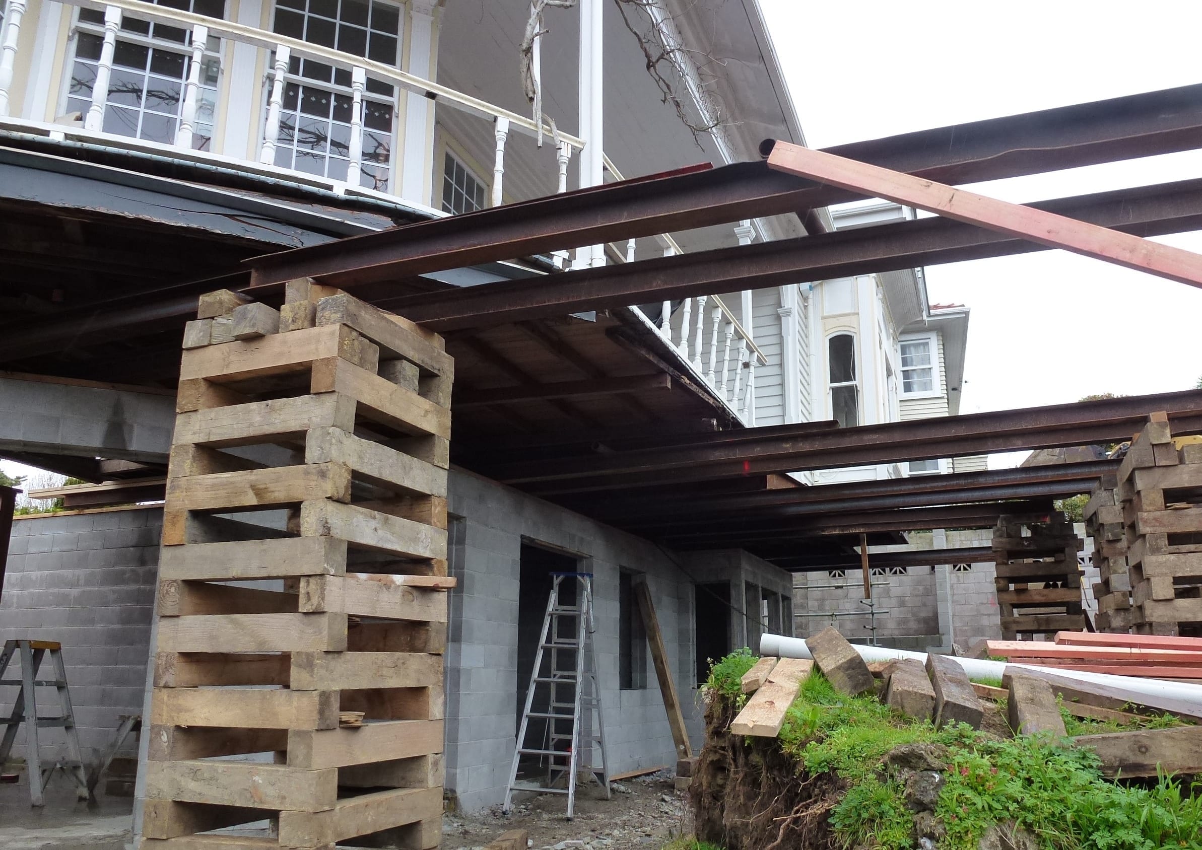 house-lifting-steel-joists-new-block-foundation House lifting with steel joists installed above a new concrete block foundation