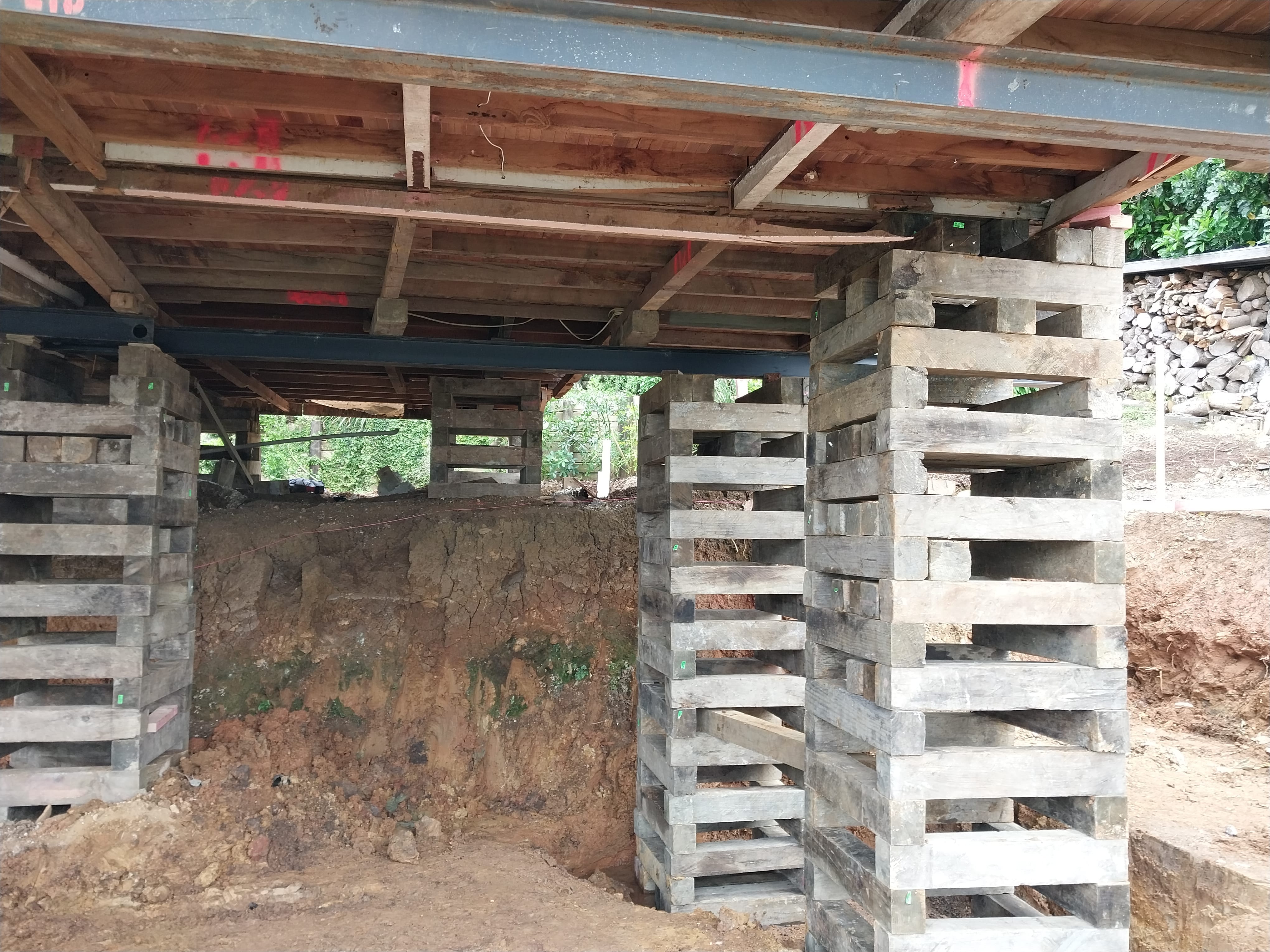 Underfloor house lifting with timber cribbing and steel beams supporting the structure