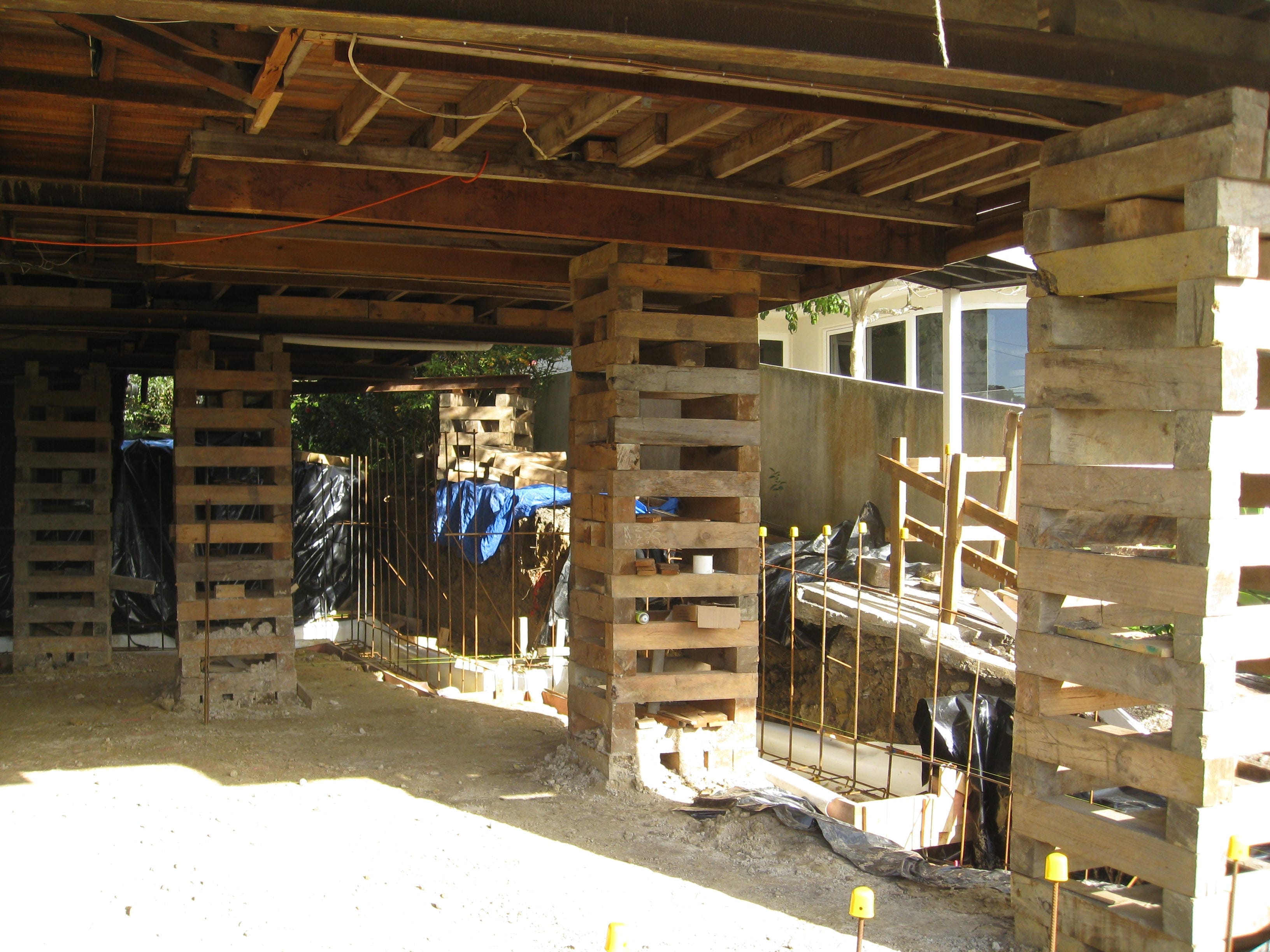 Underfloor house lifting with timber cribbing and re-piling preparation beneath the structure