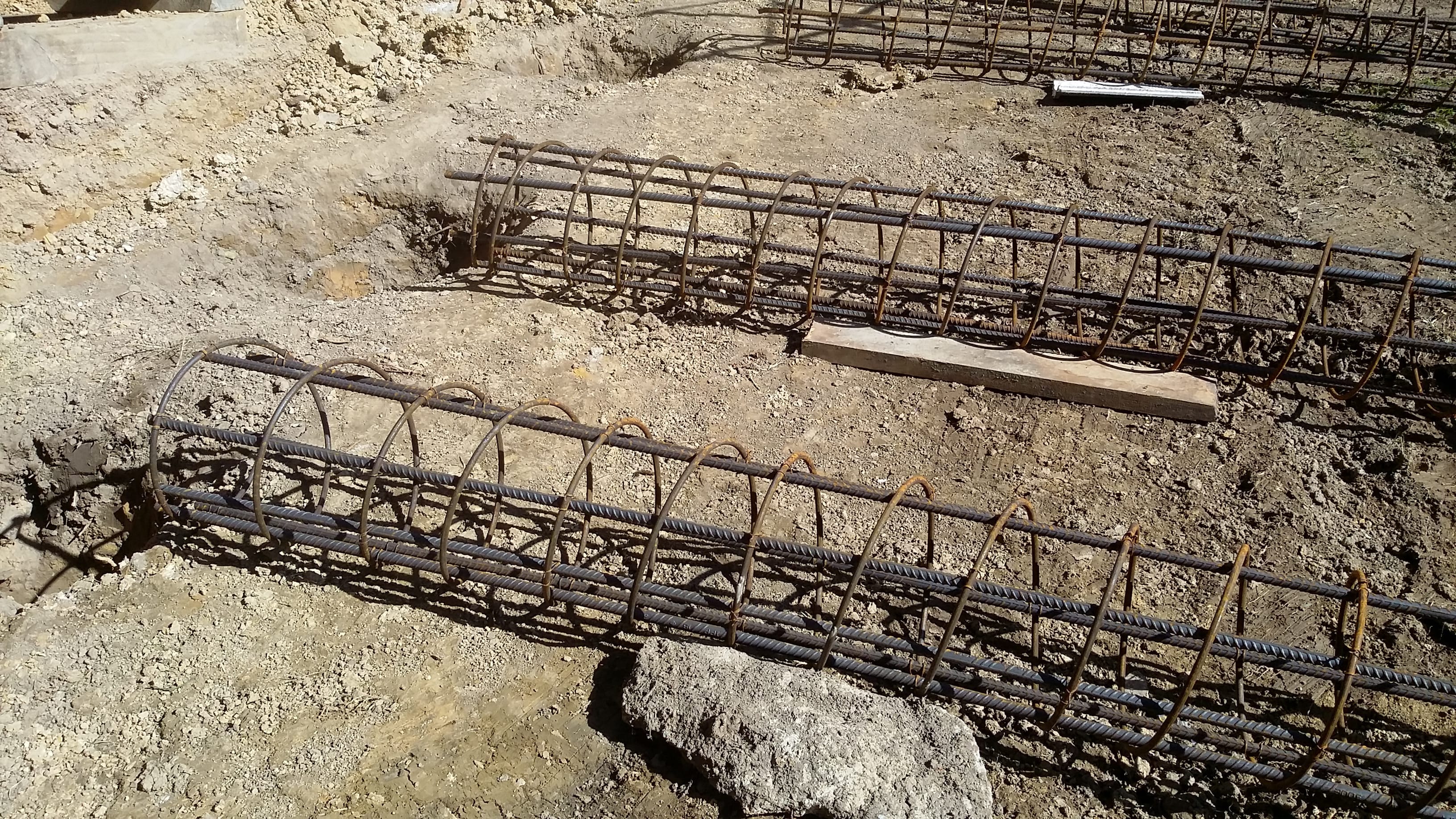 Reinforced steel rebar cages prepared for concrete beam installation during foundation construction